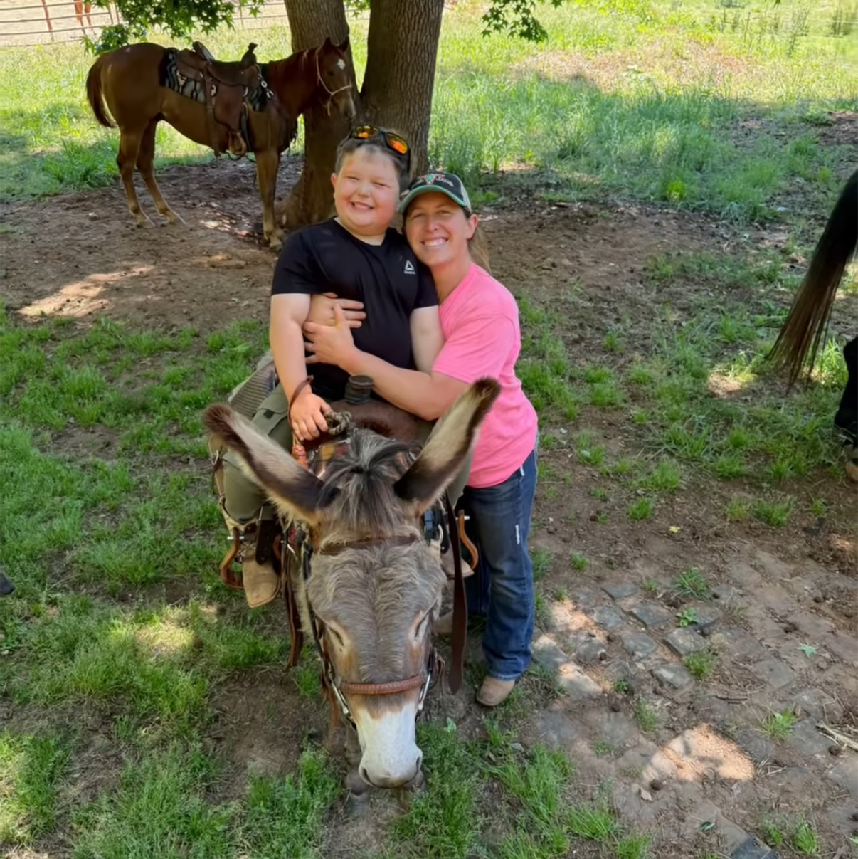 Mom hugs boy after riding donkey